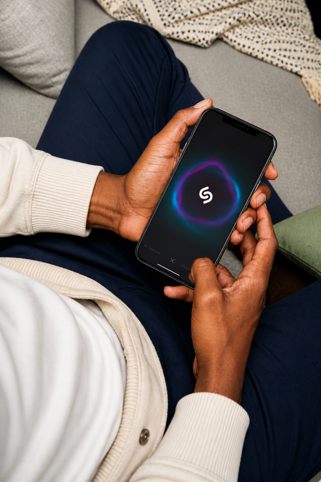 The Shazam app open in a person's hands, mid-recognition